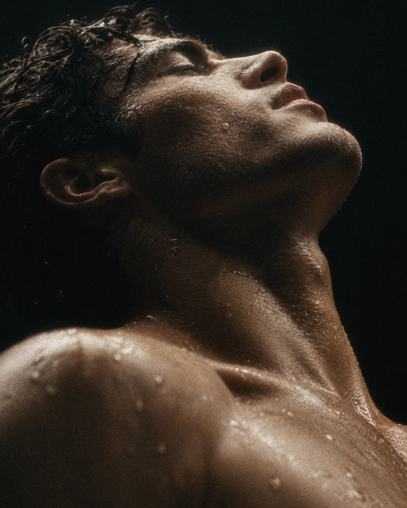 Man with a bare upper body against a dark background